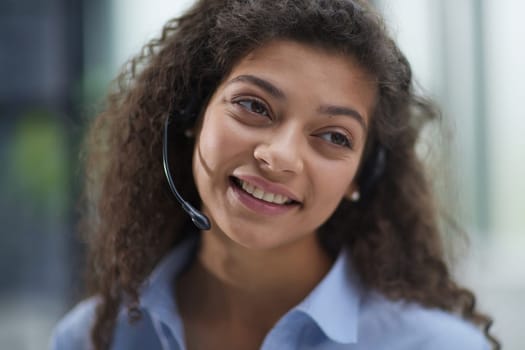 Beautiful smiling woman consultant in headphones with a microphone. Remote work from home.
