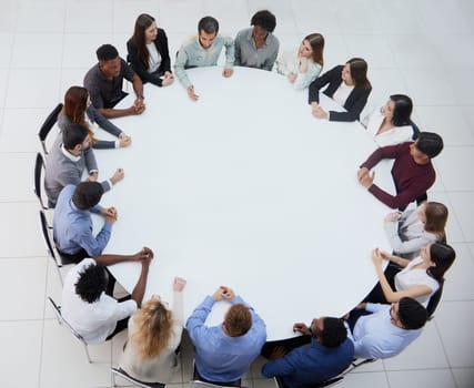 Businessmen or office workers are sitting at a round table in casual clothes.