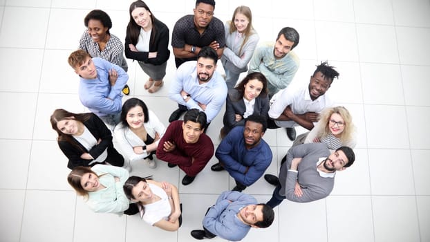 multicultural successful business group looking up in office corridor