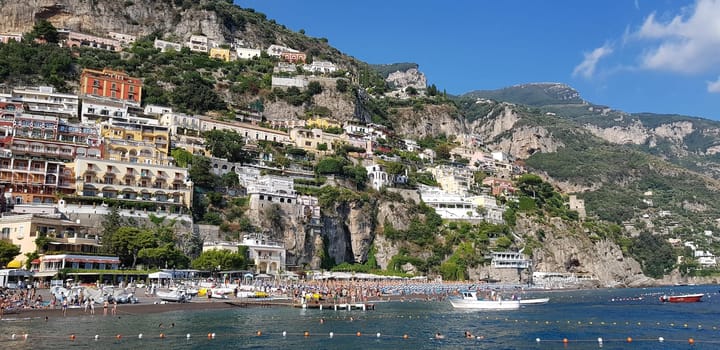 sky,tree,watercraft,water,boat,building,cloud,mountain,plant,azure,cliff,coast,rock,sea,tourism,town,village