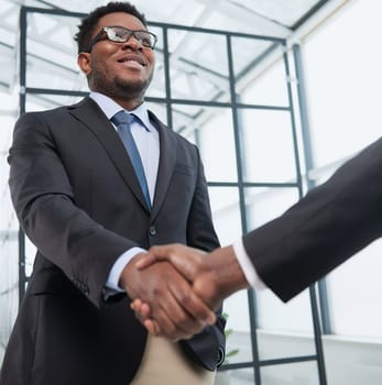 Shot of a young businessman shaking hands with a colleague in the office