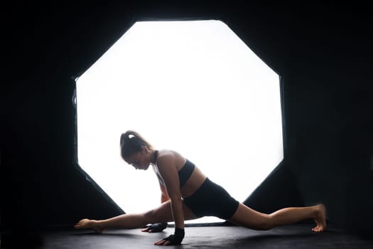 Female boxer training in a dark ring. Slow motion. Silhouette. Boxing concept