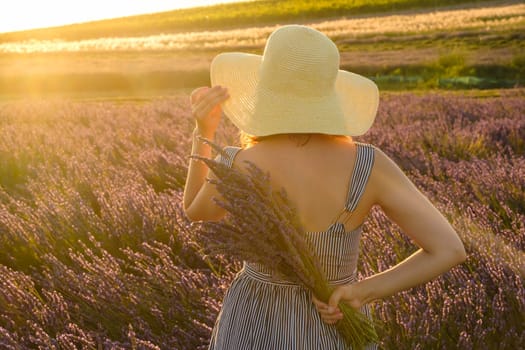 Against a backdrop of vivid lavender field, a young lady elegantly stands, her straw hat adding a touch of charm