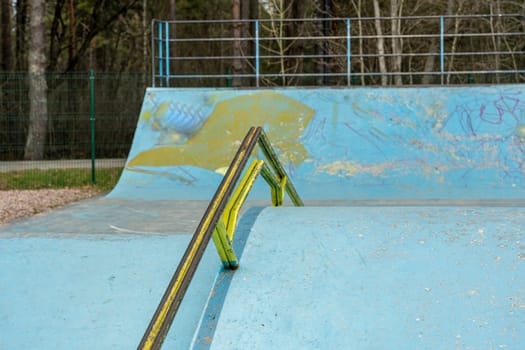 a ramp with an iron ramp for jumping in a skate park. concrete ramp for stunt scooters. The concept of a healthy lifestyle and sports leisure. extreme sports. Handrail in skate park