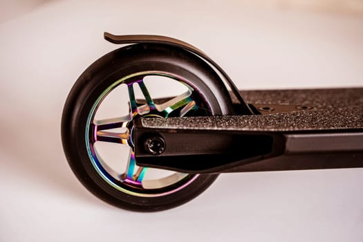 The rear wheel and brake of a Stunt scooter with rainbow-colored wheels. extreme skating in the skatepark and on the ramp. Details of the scooter. Repair and sale of extreme equipment