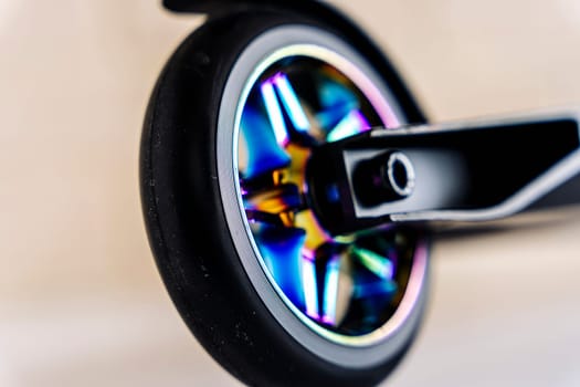 The rear wheel and brake of a Stunt scooter with rainbow-colored wheels. extreme skating in the skatepark and on the ramp. Details of the scooter. Repair and sale of extreme equipment