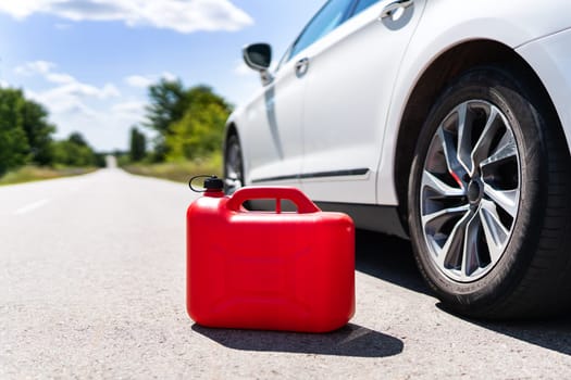 Empty car tank from a red canister on the side of the road. Fuel problem, force majeure on the road