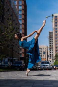 Beautiful Asian ballerina dancing outdoors. Urban landscape