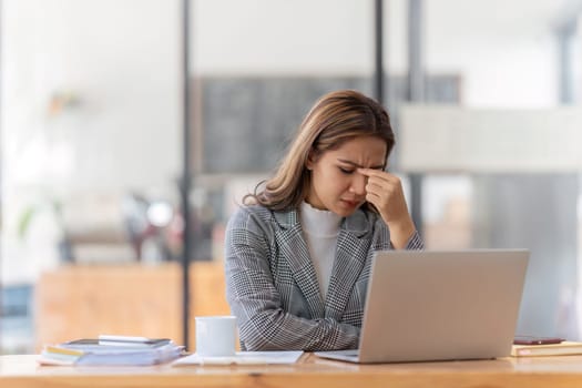 Woman working at with headache, burnout and stress over social media marketing or company deadline. Anxiety, exhausted and tired web or online business advertising expert with migraine.