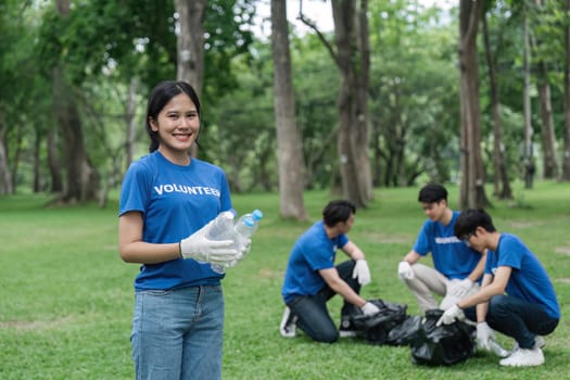 Pretty smiling female collecting forest garbage, looking at camera, volunteering.