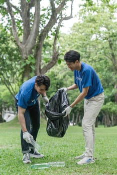 volunteering, charity, cleaning, young and ecology concept group of happy volunteers with garbage bags cleaning area.