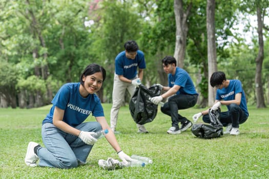 Pretty smiling female collecting forest garbage, looking at camera, volunteering.