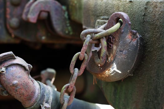 An abandoned old railway carriage with rusty metal coupling closeup