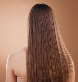 Hair care, beauty and back of woman in studio isolated on a brown background. Hair style, balayage and female model with long and healthy hair after luxury salon treatment for growth and texture