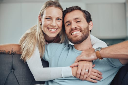 Couple, sofa and portrait for hug, smile and love for romance, relax and holding hands in living room. Happy couple, man and woman with embrace by couch, lounge and happiness at house in Los Angeles.
