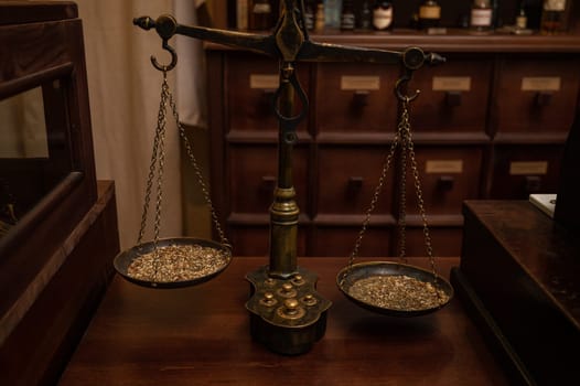 Old classic weight scale on the table of retro pharmacy from the 19th century.