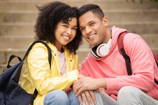 Portrait, learning and stairs with student black couple sitting outdoor together on university campus. Love, education and college with a man and woman bonding on steps while relaxing outside.