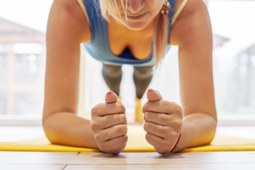 Young sports woman on a yoga mat doing the plank pose. Weight loss, healthy lifestyle concept.