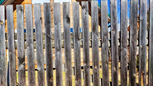 Old wooden planks in fence. Background and texture. Abstract frame and copy space. Ancient Wooden rustic rural fence