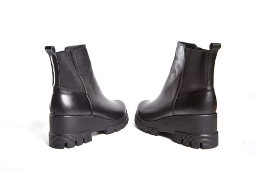Female winter, autumn or spring black leather shoes in studio. Fashionable modern photography for store, catalog, magazine or online