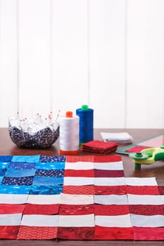 Preparing to sewing of pieces of fabrics that look like a flag of USA
