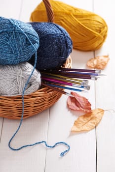 Skeins of yarn and knitting needles in basket