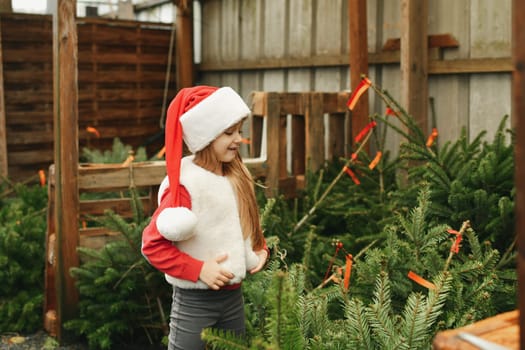 A girl chooses a christmas tree at a shop