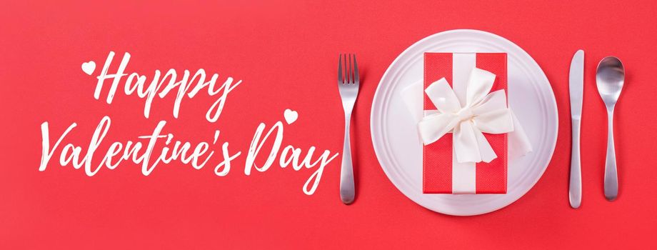 Valentine's Day holiday dating meal, banquet greeting card design concept - White plate with cutlery on red background, top view, flat lay.