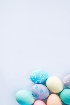 Colorful Easter eggs dyed by colored water with beautiful pattern on a pale blue background, design concept of holiday activity, top view, copy space.