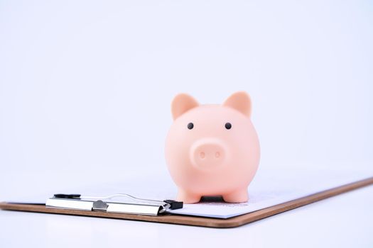 Financial concpet - Piggy bank, beautiful red white wooden house model on white background, saving money to buy insurance, close up, copy space.