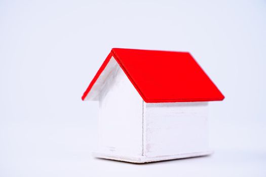 Financial concpet - Piggy bank, beautiful red white wooden house model on white background, saving money to buy insurance, close up, copy space.