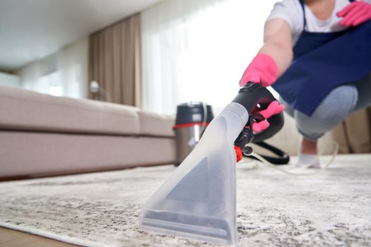 Close-up Of A Person Cleaning Carpet With Vacuum Cleaner