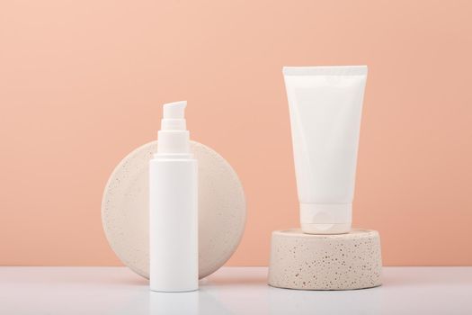 White cosmetic tubes with scrub and mask for face or head skin on white table against beige background. Concept of organic beauty products for skin, hands or hair care