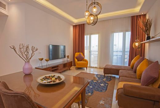 Living room lounge area in luxury apartment show home showing interior design decor furnishing with balcony terrace and dining table