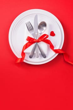 Valentine's Day meal design concept - Romantic plate dish set isolated on red background for restaurant, holiday celebration promotion, top view, flat lay.