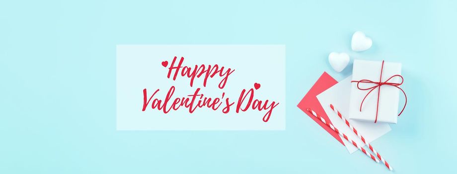 Valentine's Day handmade gift with greeting word design concept - Wrapped gift box isolated on pastel light blue color background, flat lay, top view.