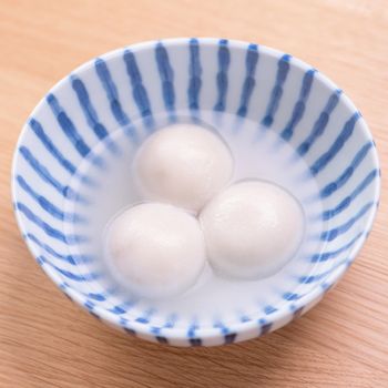 Tang yuan, tangyuan, yuanxiao in a small bowl. Delicious asian traditional festive food rice dumpling balls with stuffed fillings for Chinese Lantern Festival, close up.