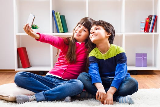Image of children taking selfie at home.