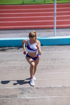 Young caucasian woman running on stadium stairs outdoors