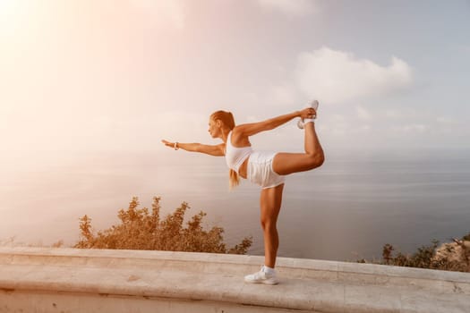 Fitness woman sea. Outdoor workout on yoga mat in park near to ocean beach. Female fitness pilates yoga routine concept. Healthy lifestyle. Happy fit woman exercising with rubber band in park.