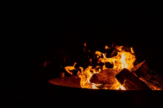 big bonfire in an old rusty fire bowl used for decoration a party.