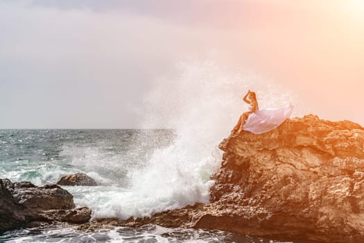 Woman sea white dress. A woman in a storm sits on a stone in the sea. Dressed in a white long dress, waves crash against the rocks and white spray rises