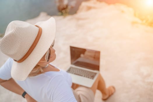 Freelance close up woman hands writing on computer. Well looking middle aged woman typing on laptop keyboard outdoors with beautiful sea view