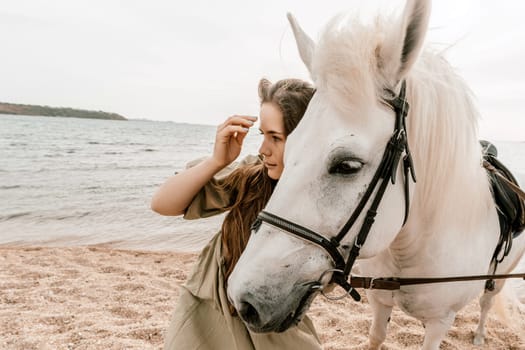 A white horse and a woman in a dress stand on a beach, with the sky and sea creating a picturesque backdrop for the scene