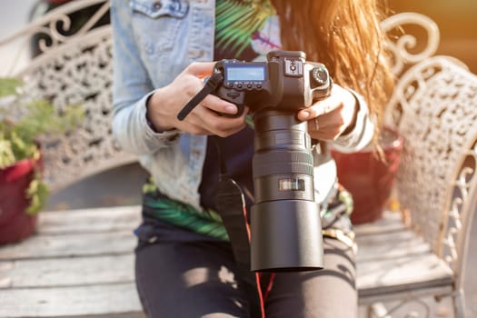 Close-up of professional female photographer on the street photographing on a camera. Photo shoot photosession in the city