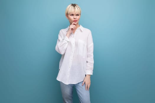 young pretty caucasian blond career woman in white blouse isolated on blue background with copy space.