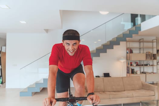 A man riding a triathlon bike on a machine simulation in a modern living room. Training during pandemic conditions