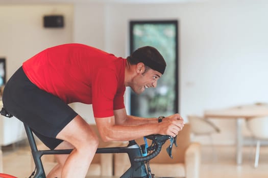 A man riding a triathlon bike on a machine simulation in a modern living room. Training during pandemic conditions