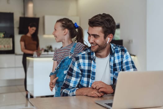 Father and daughter in the modern house talking together on a laptop with their family during holidays. The life of a modern family.