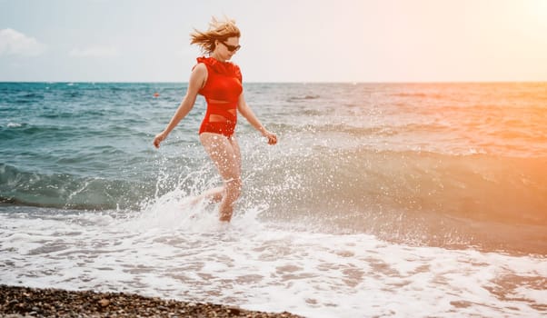 Young happy woman walks carefree on the seaside. Happy lady in red bikini. Portrait beautiful young woman relax smile around beach sea ocean in holiday vacation travel trip.